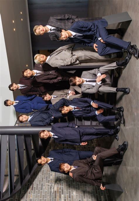 A Group Of Men Standing Next To Each Other On Top Of A Stair Case In Suits