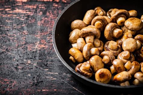 Champiñones pequeños fritos en una sartén Foto Premium