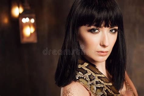 Mooi En Geheimzinnig Brunette In Een Gouden Kleding En Met Een Slang Stock Afbeelding Image Of