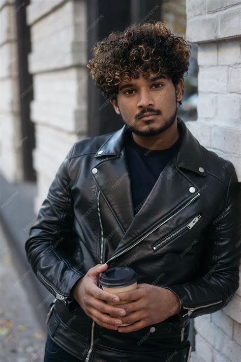 Premium Photo Handsome Serious Indian Man Wearing Black Leather Jacket Holding Cup Of Coffee