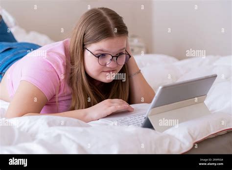 Overweight Teen Girl Watching Educational Video On Modern Tablet Lying