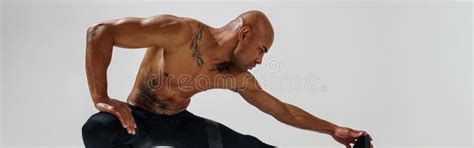 Athletic Man With Naked Torso Doing Leg Stretching Exercises Before Workout On Studio Background