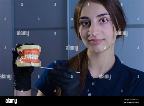 Close Up Of A Dentist Doctor Smiling Wearing Gloves Holding In His