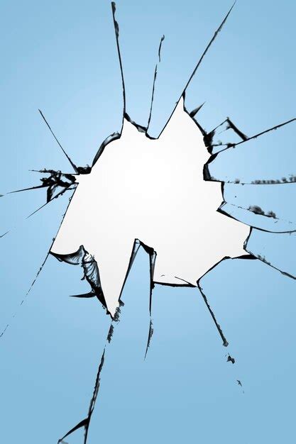 Premium Photo Pieces Of Cracked Glass With A Hole In The Center On A Blue Background Texture