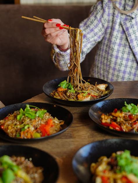 Woman Eating Noodles with Chopsticks · Free Stock Photo