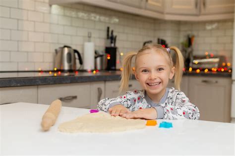 La Petite Fille Blonde Mignonne Avec Des Formes Colorées Découpe Des Biscuits Du Petit Déjeuner