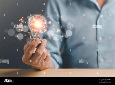 Business Man Holding Light Bulbs With Futuristic Brain Inside