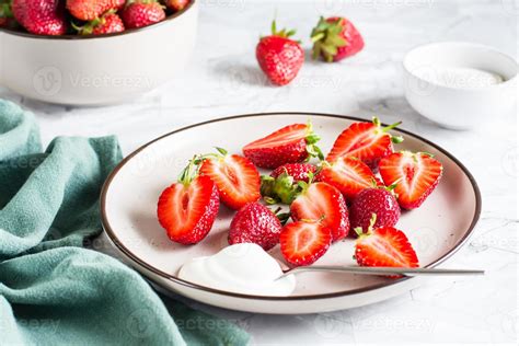 fraises fraîches tranchées et yaourt sur une assiette sur la table