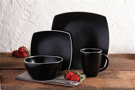 black dinnerware set on wooden table with strawberries