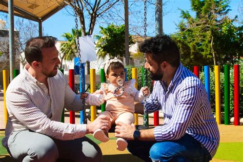 Pareja Gay Y Su Hija Joven Jugando En Los Columpios En El Parque El Día Es Soleado Y Hermoso