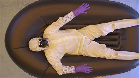 Man In Chemical Protection Suite Is Lying In An Boat Drifting On The