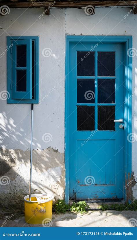 House Front Entrance With Blue Closed Door An Open Window And A Yellow