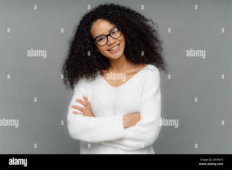 Half Length Shot Of Friendly Looking African American Woman Tilts Head