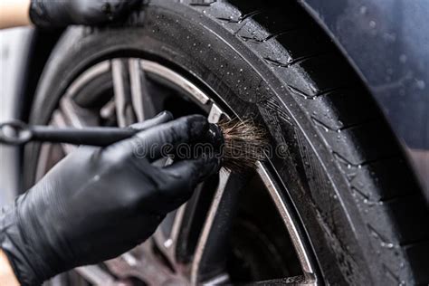 Hombre Limpiando La Rueda Del Coche Lavado De Coches Imagen De Archivo