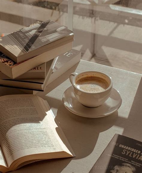 a cup of coffee sitting on top of a white saucer next to two books