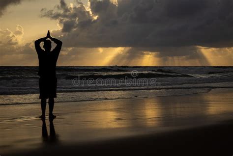 Silueta De Un Hombre Haciendo Yoga Al Amanecer Imagen De Archivo