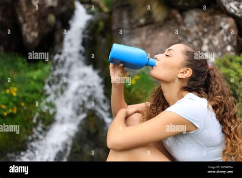 Perfil De Una Mujer Bebiendo Agua De Una Cantina En Una Cascada