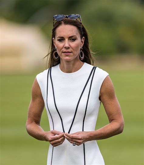 The Woman Is Wearing Sunglasses And Standing In Front Of A Green Field