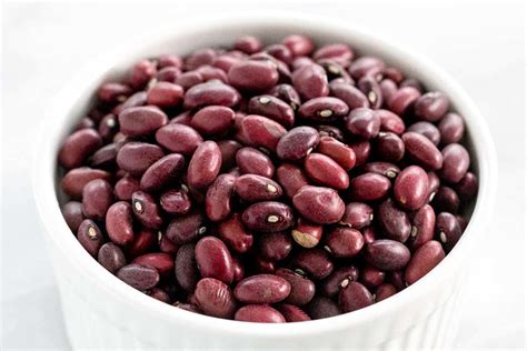 a white bowl filled with red beans on top of a table