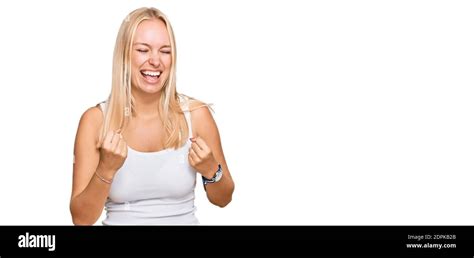 Jeune fille blonde portant un style décontracté avec une chemise sans manches célébrant surpris