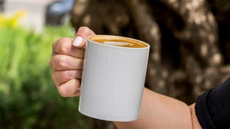 Mano sosteniendo taza de café Foto Premium