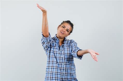 Молодая женщина поднимает руки с открытой ладонью, показывая что-то в ...