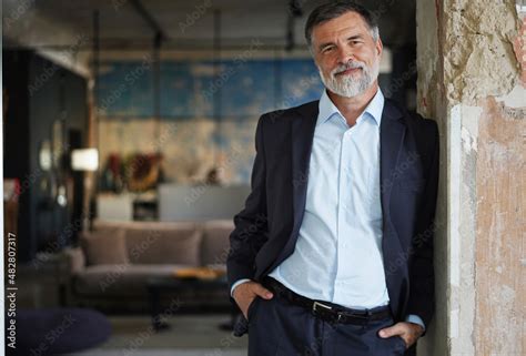 Positive Confident Mature Executive Man Smiling And Looking At Camera While Standing In Office