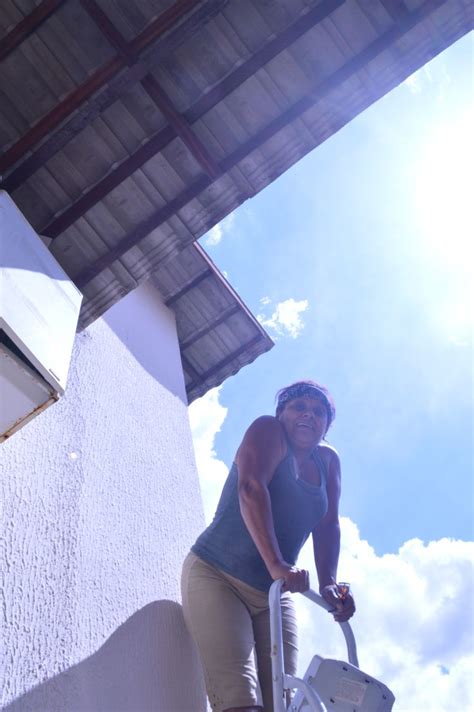 A Woman Is Climbing Up The Side Of A Building While Holding Onto A