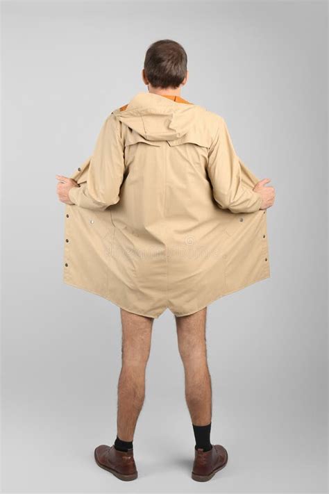 Exhibitionist Exposing Naked Body Under Coat On Light Background Back