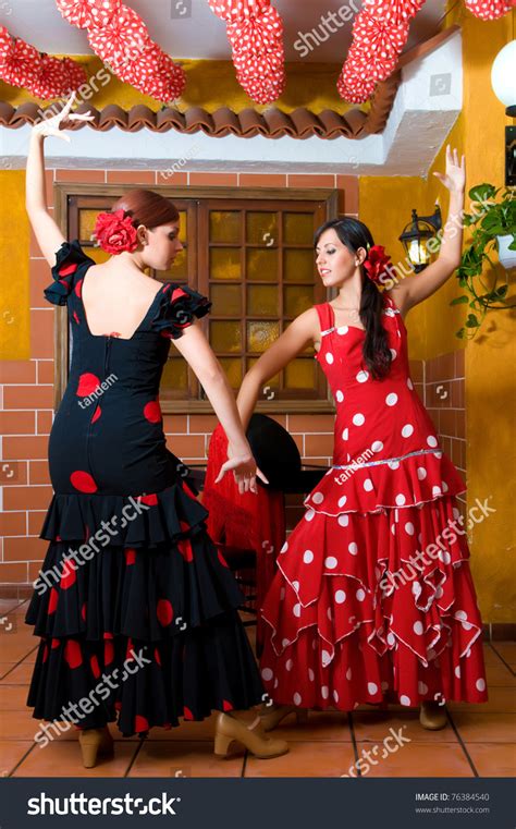 Women In Traditional Flamenco Dresses Dance During The Feria De Abril