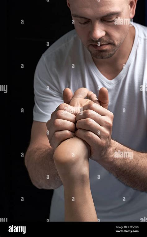 Male Masseur Hands Doing Reflexology Massage On Female Foot Reflex