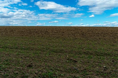 L arrière plan Est Un Champ Labouré Et De Beaux Nuages Profonds Sillons