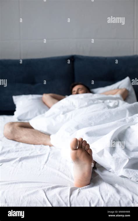 Close Up View Of Young Man Sleeping In Bed Under White Blanket In Bed