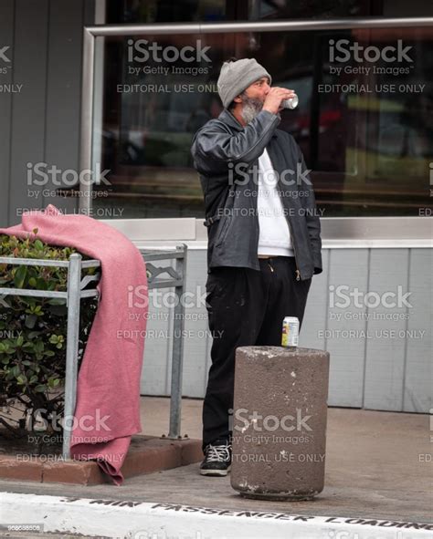 Homeless Man Drinking From A Can On Sidewalk Ocean Beach California