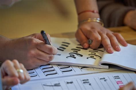 Mulher desenhando letras no álbum no estúdio de caligrafia Foto Premium