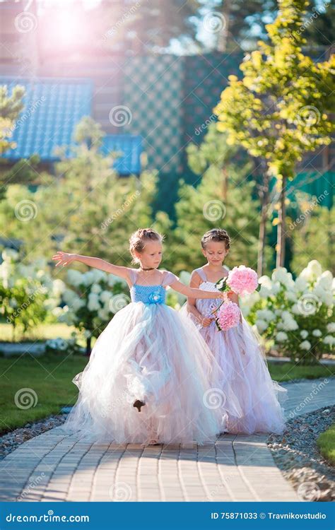 Deux Filles Adorables Avec De Beaux Bouquets Des Roses Dans Des Mains