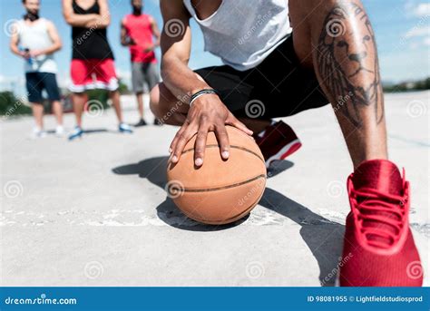 Man Holding Basketball Ball While Sitting On Court Stock Image Image