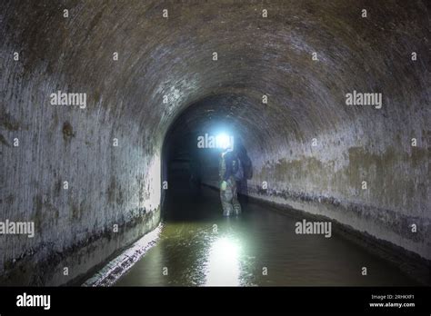 Sewer tunnel worker examines sewer system Stock Photo - Alamy