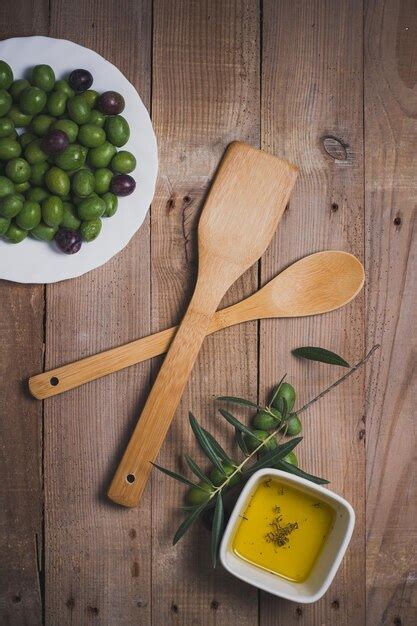 Premium Photo A Wooden Spoon And A Bowl Of Olive Oil Sit On A Wooden