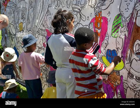 Hispanic, Arabic and African kids paint in a coloring mural. Outdoor ...