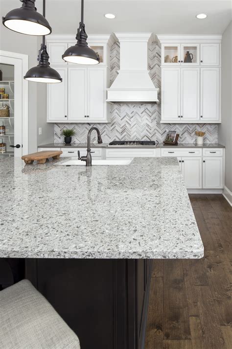 Herringbone mosaic backsplash, grey and white quartz countertops, and ...