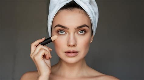 Lady In White Towel On Her Head Does Nude Makeup Using Concealer Premium AI Generated Image