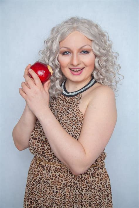 Chubby Blonde Girl Wearing Summer Dress And Posing With Big Red Apple On White Background Alone