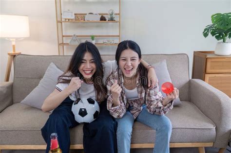 Cheerful Lesbian Couple Enjoying Football Game At Home Living Room Candid Photo Cozy Atmosphere
