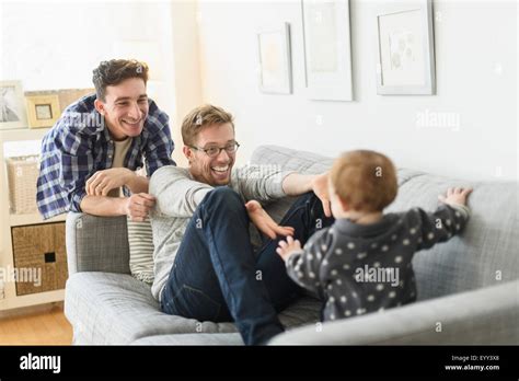Caucasian Gay Fathers And Baby Relaxing On Sofa Stock Photo Alamy