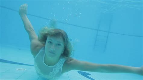 Beautiful Blonde With Long Hair In White Bikini Is Swimming Underwater