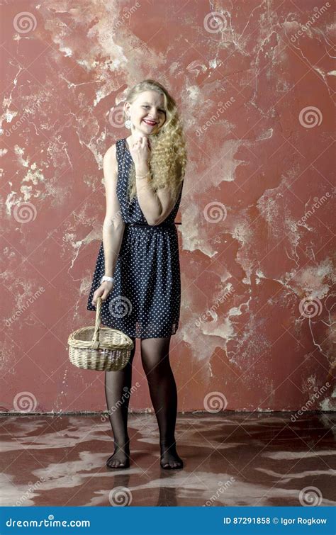 Jong Meisje Met Blonde Krullend Haar In Een Lange Kleding Met Stippen Wiiiiiiiiiiith Een Mand