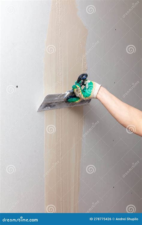 A Worker Is Plastering A Wall With A Plastering Tool Stock Photo