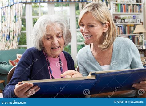 Senior Woman Looks At Photo Album With Mature Female Neighbor Stock Image Image Of Friend