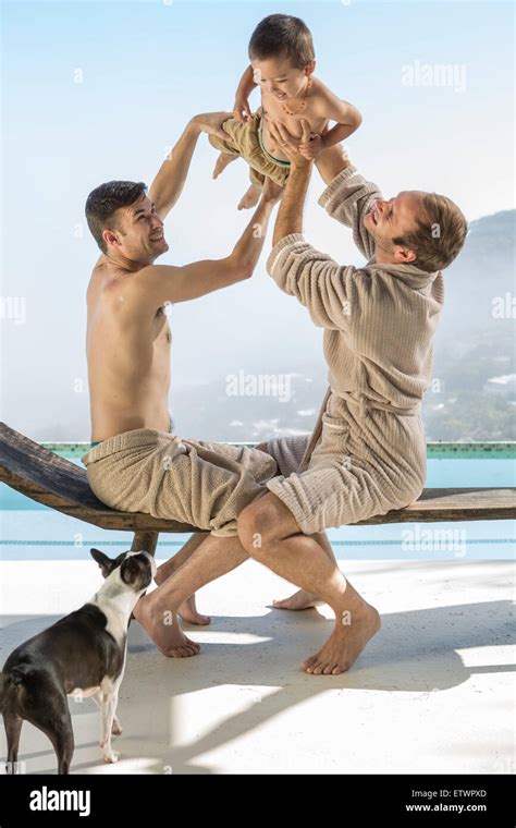 Gay Couple Playing With Baby At The Poolside Stock Photo Alamy